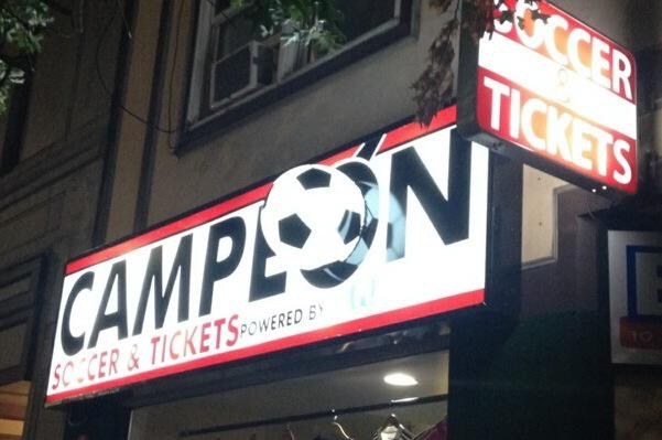 Campeón Soccer & Tickets illuminated storefront sign at night