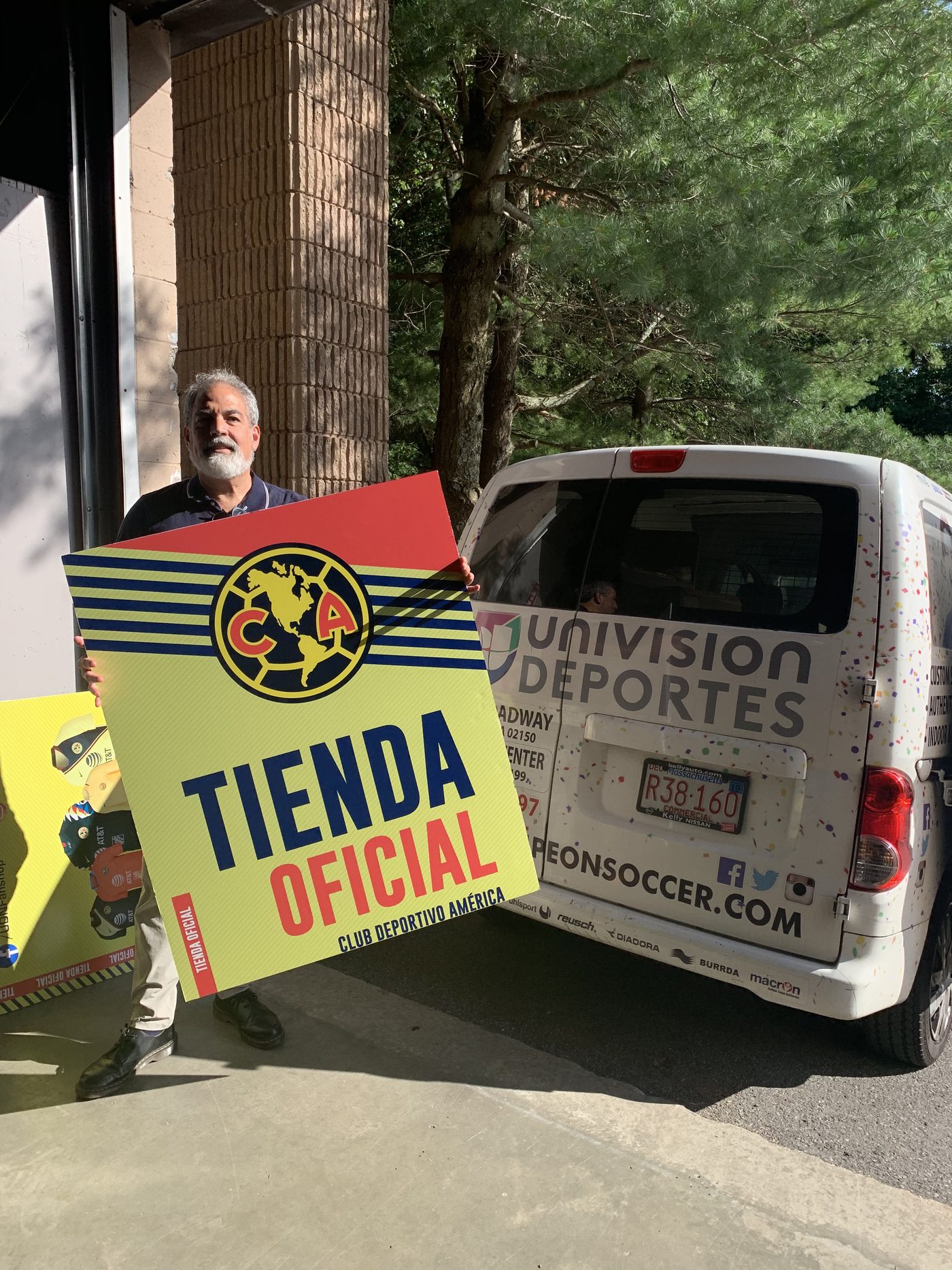 Javier Marin with Club Deportivo América official store signage beside the Univision Deportes van